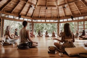 un grupo de personas sentadas en una habitación en una clase de yoga en Awake Uvita, en Uvita