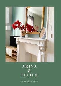 une cheminée avec un miroir et un vase avec des fleurs rouges dans l'établissement Arina & Julien, à Dieppe