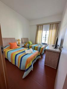 um quarto de hotel com duas camas e uma janela em Residence Golf-Vilamoura! em Quarteira
