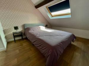 um quarto com uma cama num quarto com uma janela em Champagne Cocooning em Reims