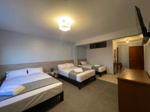 a hotel room with two beds and a table at Izza Hotel in Cochabamba