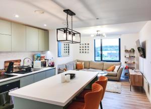 cocina y sala de estar con mesa y sillas en Luxe Apartment: 3 mins Luton Airport & Free Wi-Fi, en Luton
