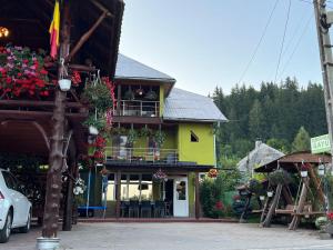 a building with a balcony with flowers on it at Pensiunea Gaiu in Albac