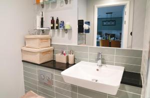 ein Bad mit einem Waschbecken und einem Spiegel in der Unterkunft Luxe Apartment: 3 mins Luton Airport & Free Wi-Fi in Luton