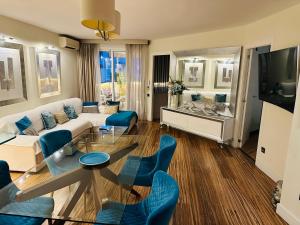 a living room with a white couch and blue chairs at Luxury Apartament in Marina in Benalmádena