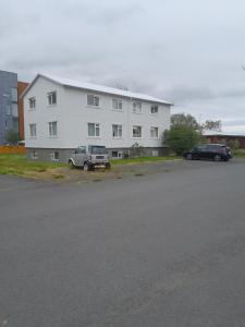 a white building with two cars parked in front of it at Kyrrðarstaður in Selfoss