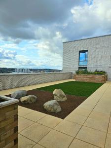 un edificio con tres rocas grandes en un patio en Luxe Apartment: 3 mins Luton Airport & Free Wi-Fi, en Luton