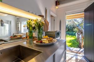 une cuisine avec une plaque de cuisson sur un comptoir dans l'établissement Welcome Cottage - Stay Waiheke, à Oneroa