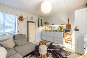 un salon avec un canapé et une cuisine dans l'établissement Welcome Cottage - Stay Waiheke, à Oneroa 25 autres photos