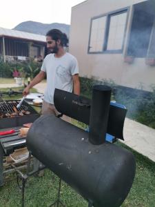 a man standing in front of a grill at Arlin Bungalows in Kemer