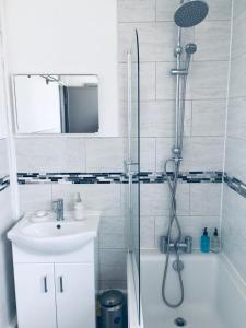 a bathroom with a shower and a sink and a tub at Elsham Gardens Rooms - Shared Facilities in Manchester