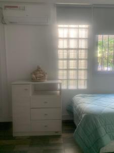 a bedroom with a dresser and a bed and windows at Sweet Home in Vicente López