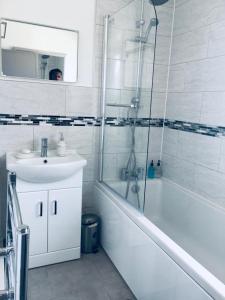 a bathroom with a sink and a shower and a tub at Elsham Gardens Rooms - Shared Facilities in Manchester