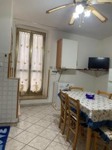 een keuken met een tafel en stoelen en een tafel en een plafondventilator bij La Libellula in Ortona