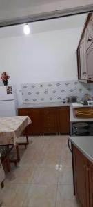 cocina con mesa y fogones horno superior en Sanos GardenApartament, en Sarandë