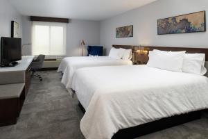 a hotel room with two beds and a flat screen tv at Hilton Garden Inn Baton Rouge Airport in Baton Rouge +23 photos