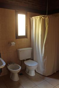 baño con aseo y lavabo y ventana en Bungalow Pai-Pay 2 en San Carlos de Bariloche