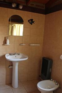 a bathroom with a sink and a mirror and a toilet at Bungalow Pai-Pay 2 in San Carlos de Bariloche