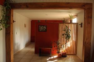 un pasillo con macetas y una pared roja en Bungalow Pai-Pay 2 en San Carlos de Bariloche