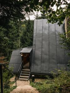 a black clad house with stairs leading up to it at Chata Jozef in Sabinov