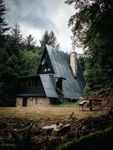 a barn with a black roof on a field at Chata Jozef in Sabinov