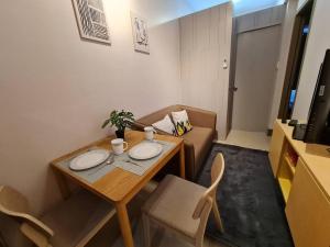 - un petit salon avec une table et un canapé dans l'établissement Chic 2 BR EDSA APT w/ Balcony Netflix Prime Video, à Manille