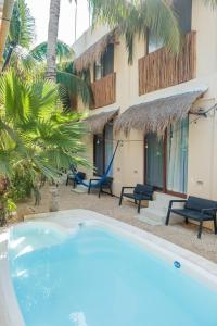 a swimming pool in front of a building at Hotel Pelecanus Suites Holbox in Holbox Island