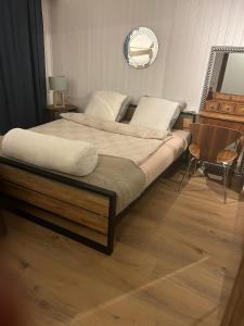 un grande letto in una camera da letto con pavimento in legno di Chez Pipo a Conthey