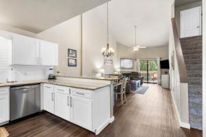 a kitchen with white cabinets and a living room at Gorgeous 3 Bed 3 Bath Pointe Royale Condo Branson MO in Branson