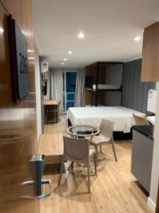 a hotel room with a bed and a table and chairs at BLUE SUNSET PREMIUM - Flat Beira Mar para até 5 pessoas - Cabo Branco - Piscina Rooftop in João Pessoa