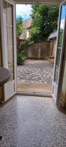 an open door to a courtyard with a stone floor at Super Appartement in La Souterraine