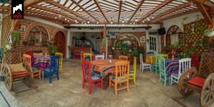 un restaurante con mesas y sillas coloridas en una habitación en TEYFA Hospedaje - Casa, en Atuntaqui