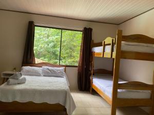 1 dormitorio con 2 literas y ventana en Ukinca B&B, en Uvita