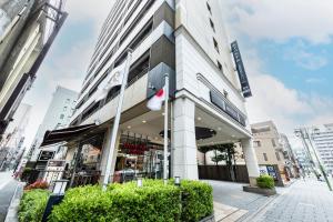 a building with a flag in front of it at APA Hotel Kyoto Ekimae Chuoguchi in Kyoto