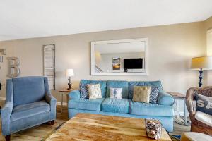 a blue couch and a chair in a living room at The Southern Harmony in Folly Beach