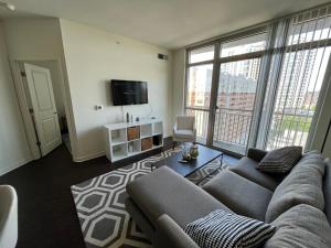 a living room with a couch and a tv at Cozy 1BR Apartment In Downtown Silver Spring MD in Silver Spring