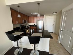 a kitchen with a black counter top and wooden cabinets at Cozy 1BR Apartment In Downtown Silver Spring MD in Silver Spring