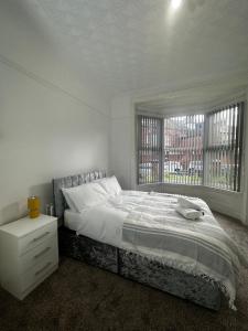 - une chambre blanche avec un lit et une fenêtre dans l'établissement Le Crescent Lodge, Room Stay , Middlesbrough City, à Middlesbrough