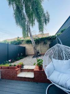 a hammock on a patio with a tree at Riverside Premium En suite Double Room E14 in London