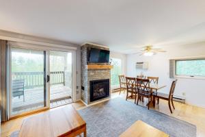 a living room with a fireplace and a table and chairs at Mountainside Resort B202 in Stowe