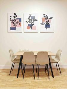 stół jadalny z czterema krzesłami i obrazami na ścianie w obiekcie 2 Bedroom Apartment 2BB w Rijadzie