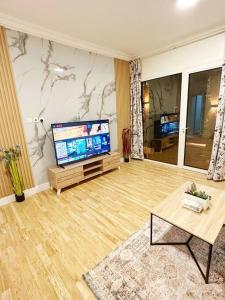 a living room with a large flat screen tv at شقة جميلة بغرفتين نوم ومدخل خاص 2BB in Riyadh
