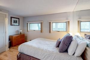 ein Schlafzimmer mit einem Bett und zwei Fenstern in der Unterkunft Mountainside Resort B202 in Stowe