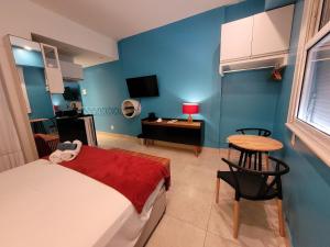 um quarto com uma cama, uma mesa e uma secretária em Estúdio frente mar de Copacabana WIFI 500M no Rio de Janeiro