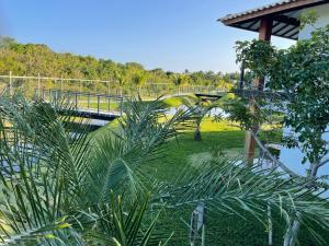 uma ponte sobre um parque com palmeiras e uma ponte em INCRIVEL apartamento com vista lago! em Praia do Forte