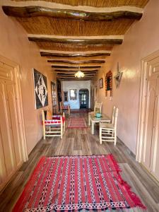 a living room with a red rug on the floor at Kasbah El Hajja in Aït Benhaddou