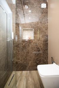 a bathroom with a shower with a toilet and a sink at Queen Apartmets Vlore in Vlorë