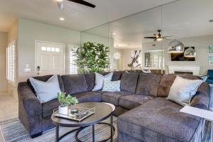 a living room with a brown couch and a table at Beautiful Palm Desert Townhome with Community Perks! in Palm Desert