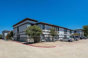 un gran edificio con coches estacionados en un estacionamiento en Quality Inn & Suites DFW Airport South, en Irving