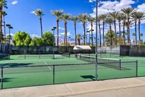 two tennis courts with palm trees in the background at Beautiful Palm Desert Townhome with Community Perks! in Palm Desert